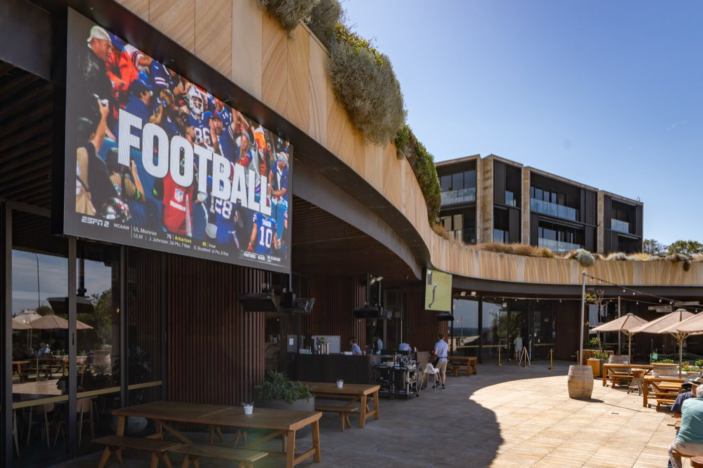 The Ocean Terrace under a blue sky, with the big outdoor screen