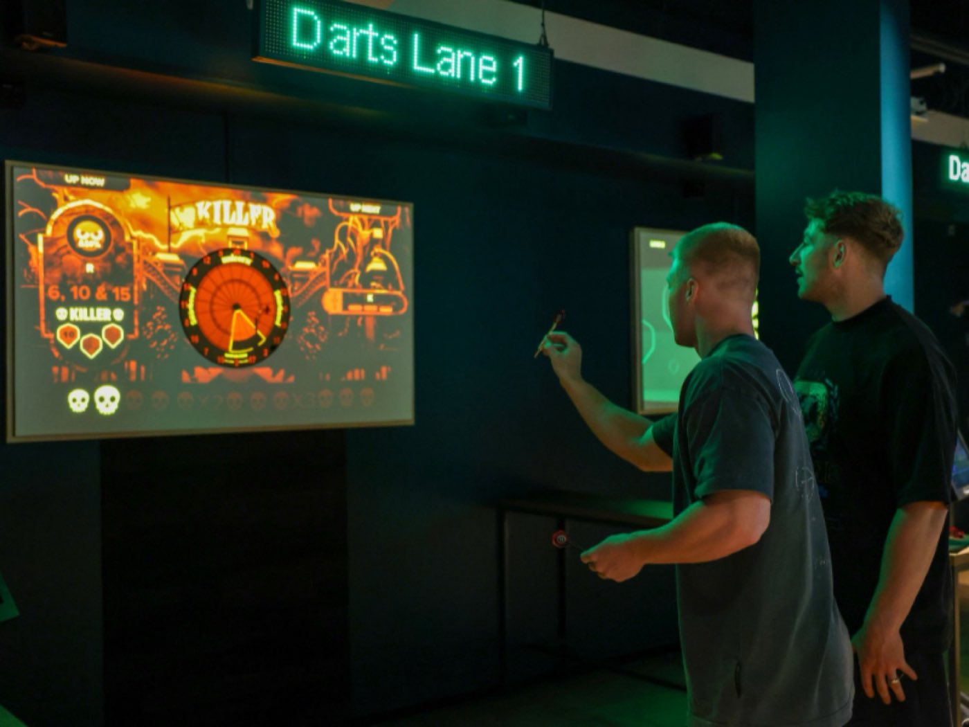 Players at an augmented-reality darts lane