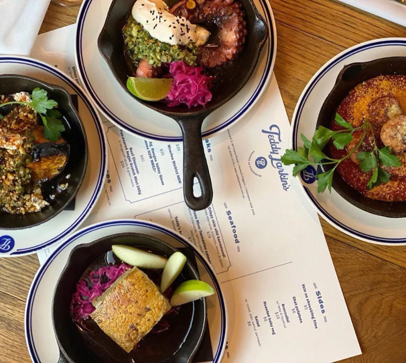 Dark plates and a menu on the table, seen from above